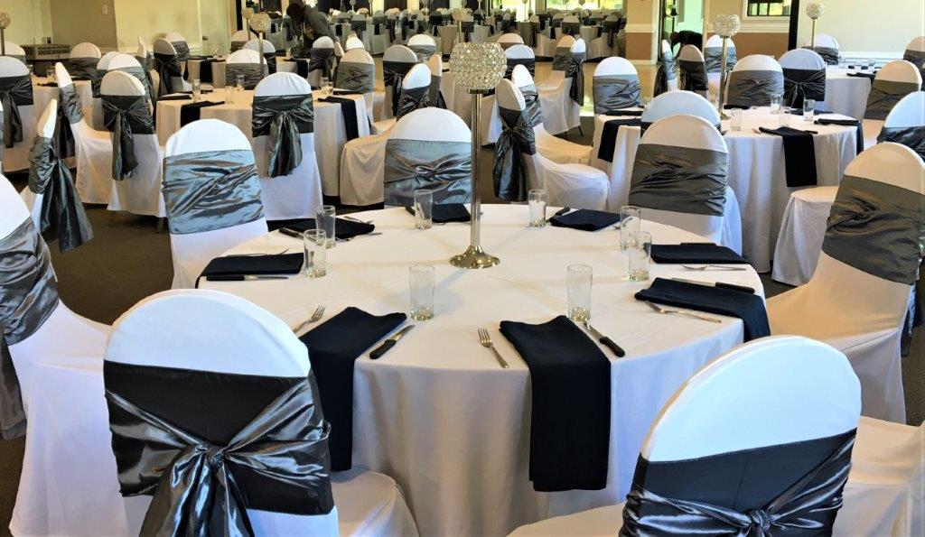 White Chair Covers with Black Satin Sashes and Silver Satin Sash Overlays at Conestoga Country Club